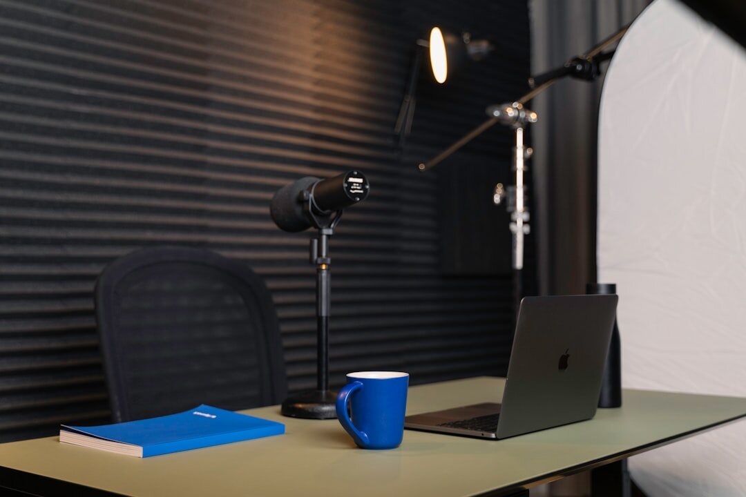 Small creative studio desk with cameras, notebooks and a lamp