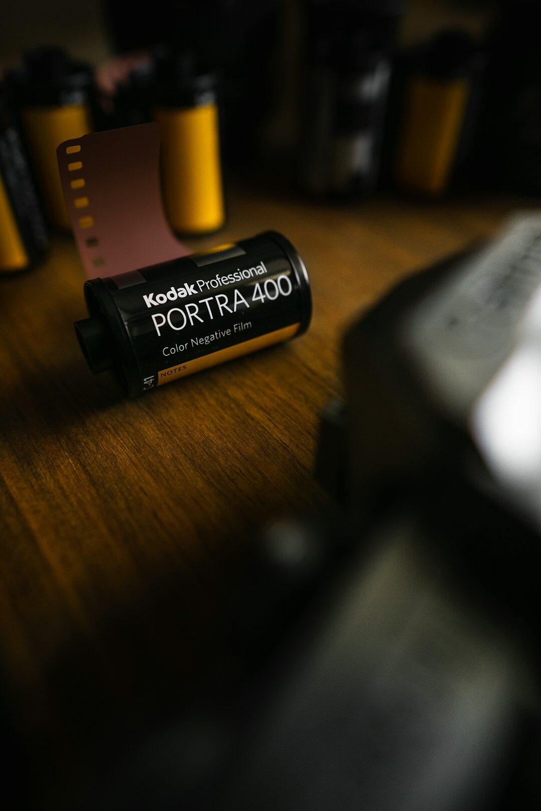 Close up of a vintage camera and rolls of film on a wooden table